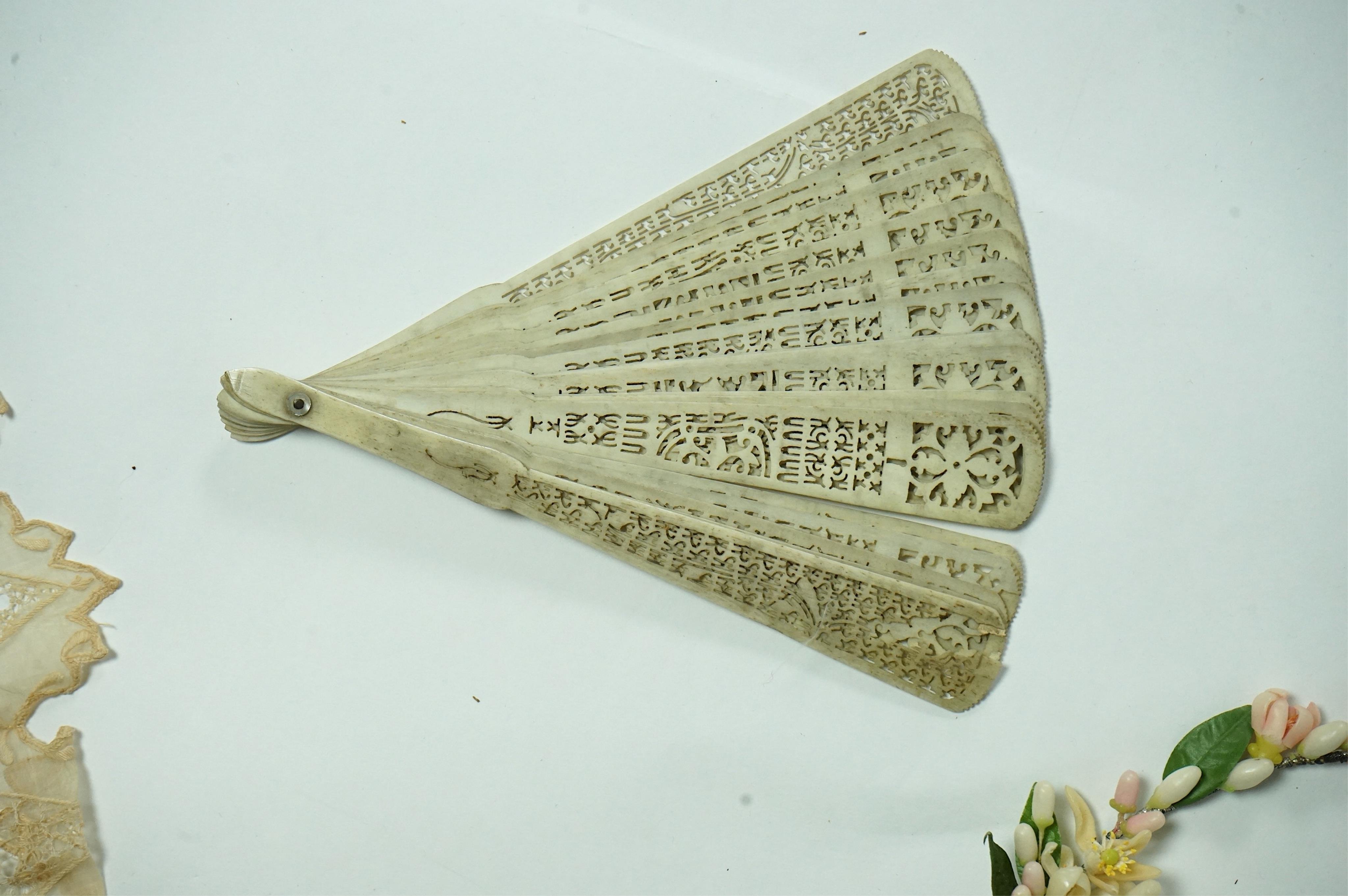 A 1920’s wax wedding headdress, a white feather fan, a bone brise and an earlier long lawn embroidered and lace worked stole., Stole 194cm long. Condition - headdress and fan good, stole has moth holes in places but can